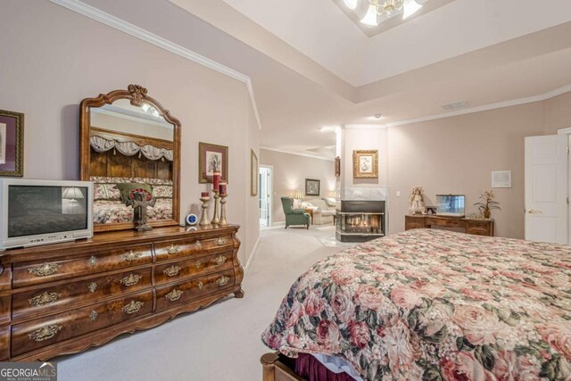 bedroom with visible vents, ornamental molding, carpet flooring, a glass covered fireplace, and a raised ceiling