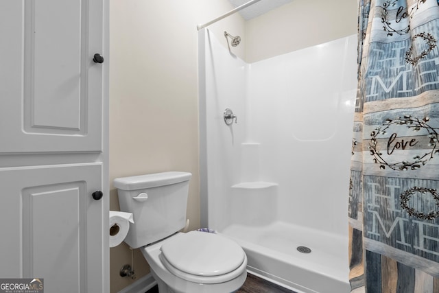 bathroom with a stall shower and toilet