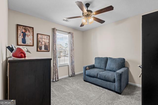 living area featuring visible vents, ceiling fan, baseboards, and carpet