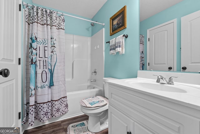 bathroom with toilet, vanity, wood finished floors, shower / bath combination with curtain, and a textured ceiling