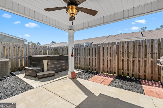 view of patio with central air condition unit, a ceiling fan, a fenced backyard, and a hot tub