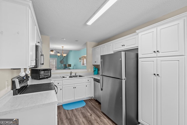 kitchen featuring white cabinetry, light countertops, appliances with stainless steel finishes, and a sink