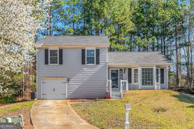 split level home with a garage, driveway, central AC, and a front lawn