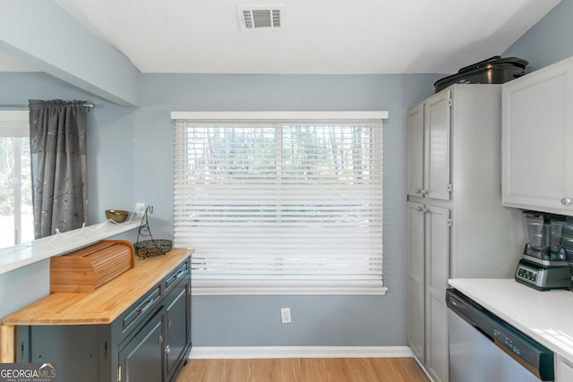 kitchen with light wood finished floors, visible vents, a healthy amount of sunlight, and dishwasher