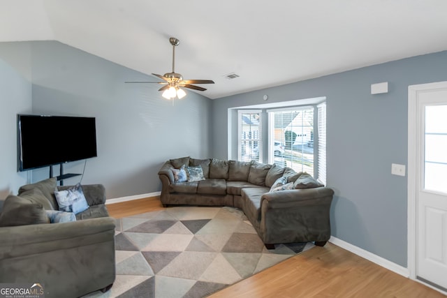 living room with a ceiling fan, baseboards, visible vents, lofted ceiling, and light wood-type flooring