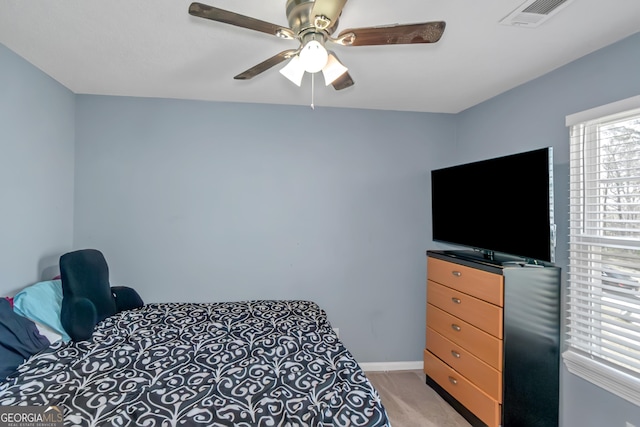 bedroom featuring visible vents, light carpet, baseboards, and ceiling fan