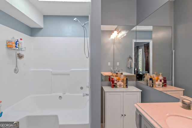 bathroom featuring washtub / shower combination and vanity