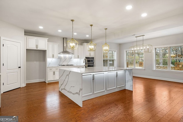 kitchen featuring wall chimney range hood, dark wood-style floors, and white cabinets