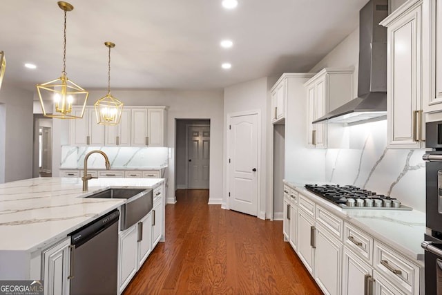 kitchen with a sink, dark wood-style floors, recessed lighting, appliances with stainless steel finishes, and wall chimney exhaust hood