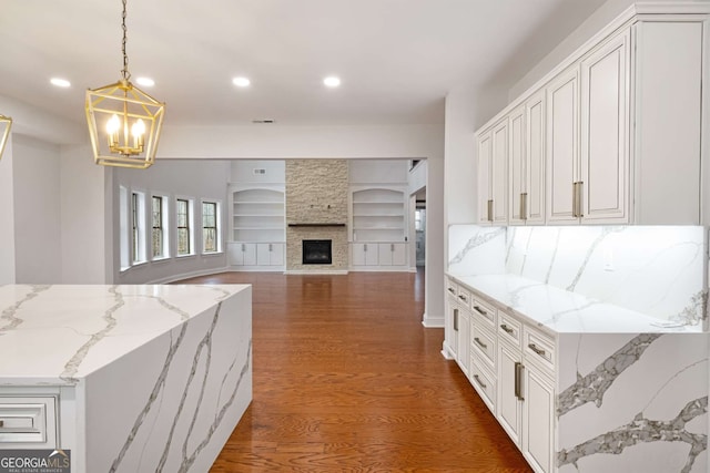 kitchen featuring built in features, recessed lighting, a fireplace, and dark wood-style flooring