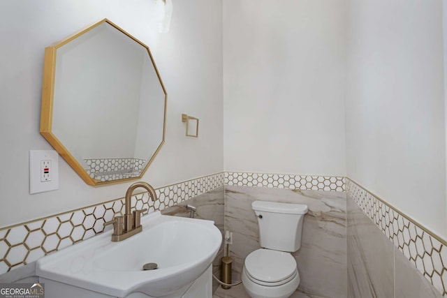 bathroom featuring a wainscoted wall, toilet, tile walls, and vanity