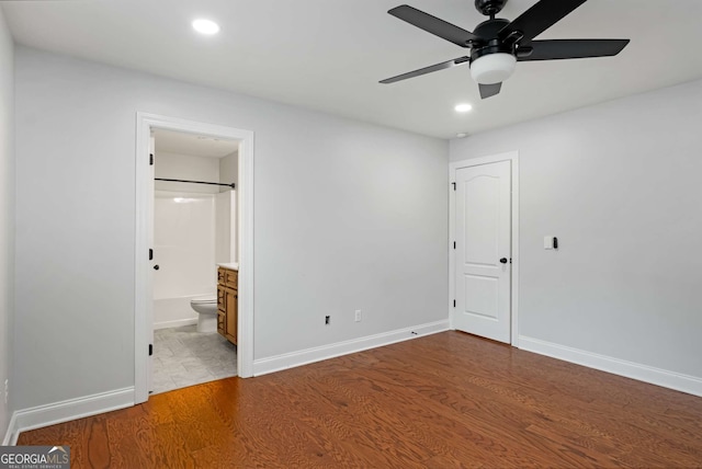 unfurnished bedroom with recessed lighting, wood finished floors, and baseboards