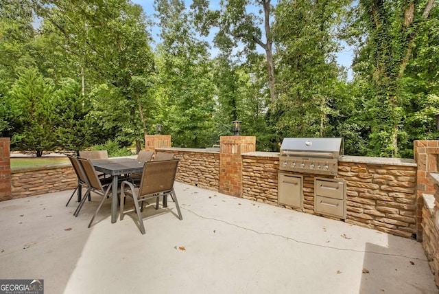 view of patio with outdoor dining space, exterior kitchen, and area for grilling