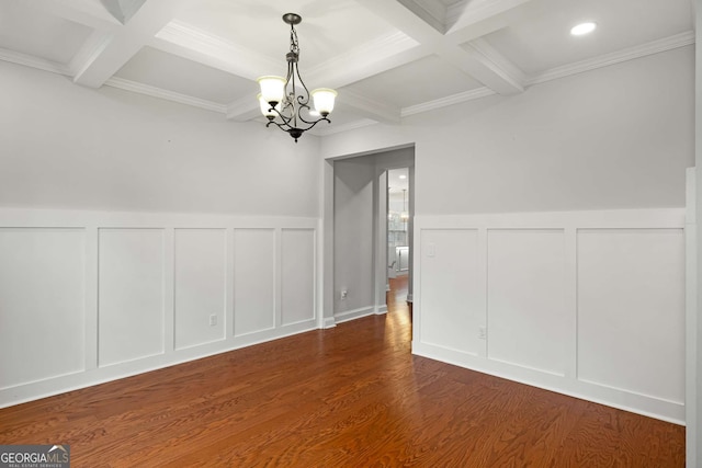 unfurnished dining area featuring wood finished floors, coffered ceiling, beamed ceiling, a decorative wall, and a chandelier