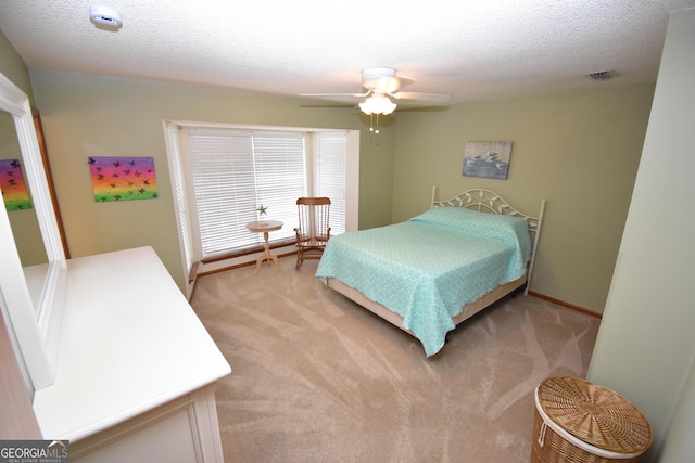 bedroom with visible vents, baseboards, light carpet, a textured ceiling, and a ceiling fan