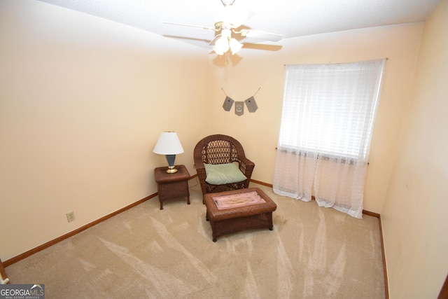 living area featuring baseboards, carpet floors, and ceiling fan