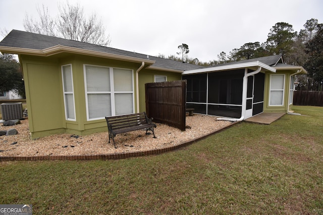 back of house with cooling unit, fence, a yard, and a sunroom