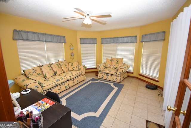 living room with tile patterned flooring, a ceiling fan, and a textured ceiling