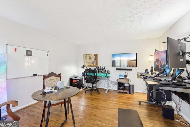 office space featuring baseboards, a textured ceiling, and wood finished floors