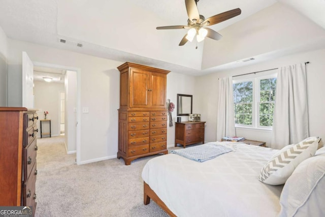 bedroom with visible vents, baseboards, lofted ceiling, a tray ceiling, and light carpet