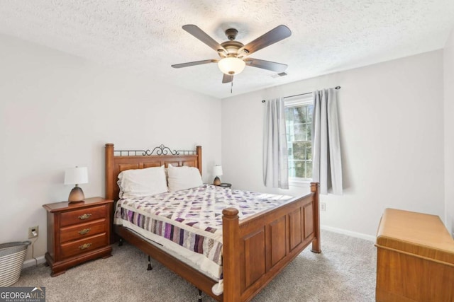 bedroom with a ceiling fan, baseboards, visible vents, a textured ceiling, and light carpet