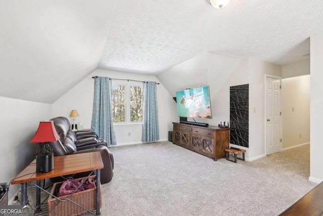 sitting room with baseboards, a textured ceiling, carpet, and lofted ceiling