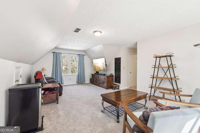 living area featuring visible vents, lofted ceiling, a textured ceiling, carpet floors, and baseboards