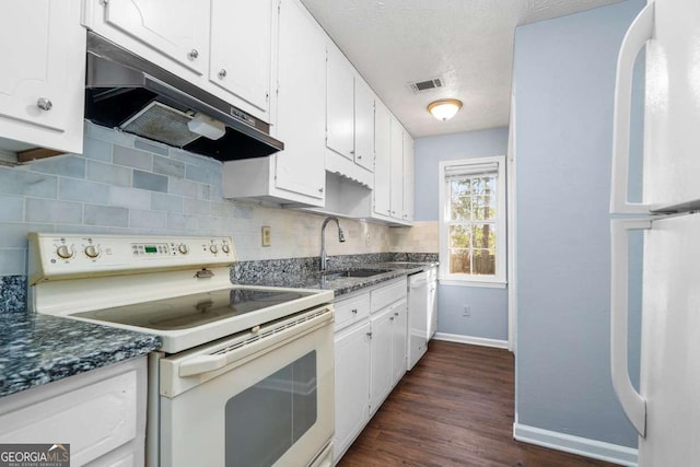 kitchen featuring decorative backsplash, white appliances, under cabinet range hood, and a sink