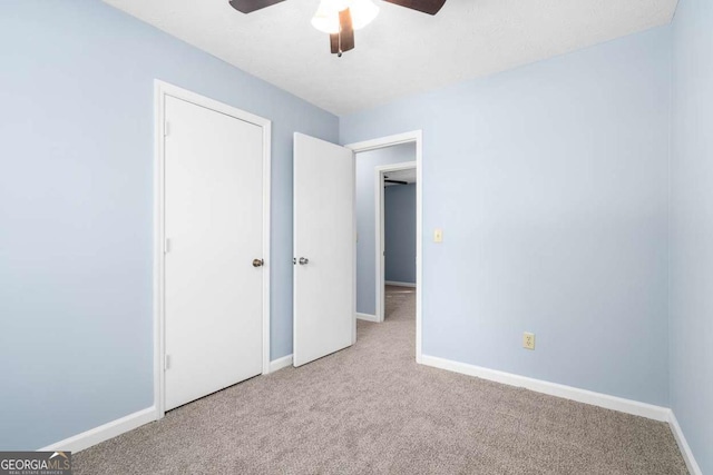 unfurnished bedroom featuring a ceiling fan, baseboards, and carpet floors