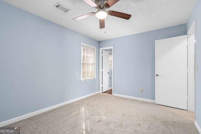 unfurnished bedroom with carpet, baseboards, visible vents, and a textured ceiling