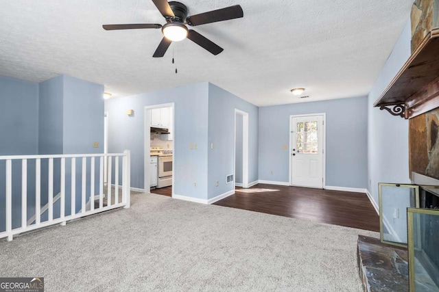 entryway with dark wood-style floors, baseboards, dark carpet, and a textured ceiling