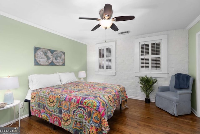 bedroom with crown molding, wood finished floors, visible vents, and baseboards