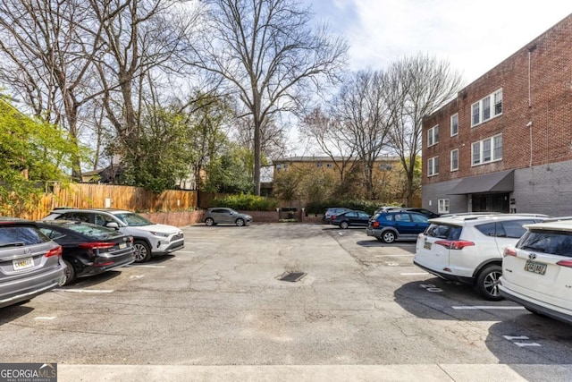 uncovered parking lot featuring fence