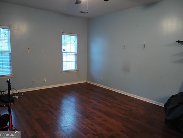 unfurnished room featuring a ceiling fan, visible vents, wood finished floors, and baseboards