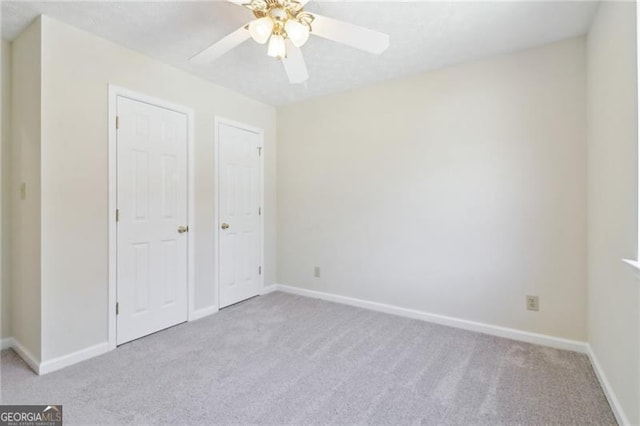 unfurnished bedroom featuring a ceiling fan, carpet, and baseboards