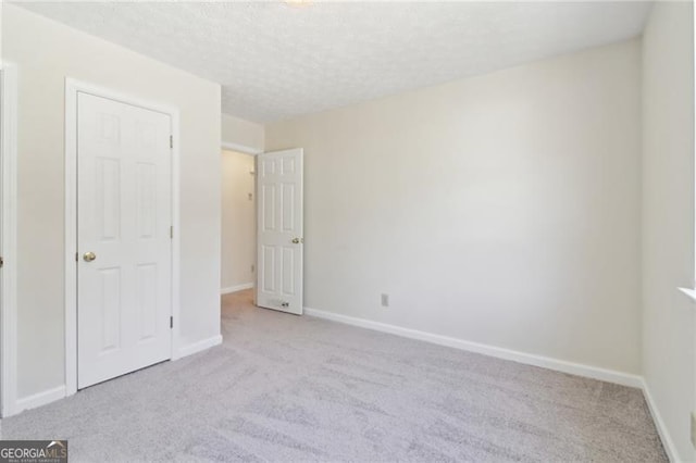 unfurnished bedroom featuring a textured ceiling, baseboards, and carpet floors