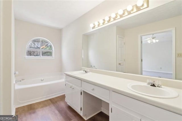 full bath featuring a sink, wood finished floors, a bath, and double vanity