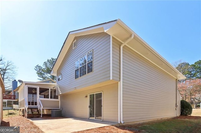 back of property featuring central air condition unit, a patio, and a sunroom