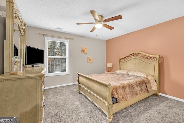 bedroom with a textured ceiling, carpet, visible vents, and baseboards