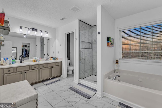 bathroom featuring marble finish floor, a shower stall, and a sink