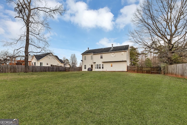 back of property featuring a lawn and a fenced backyard