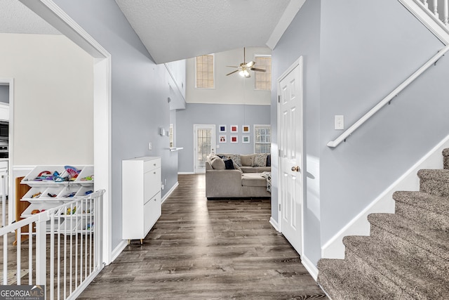 entrance foyer featuring stairs, wood finished floors, a textured ceiling, high vaulted ceiling, and a ceiling fan