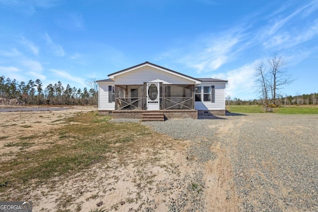 manufactured / mobile home with crawl space, gravel driveway, and a sunroom