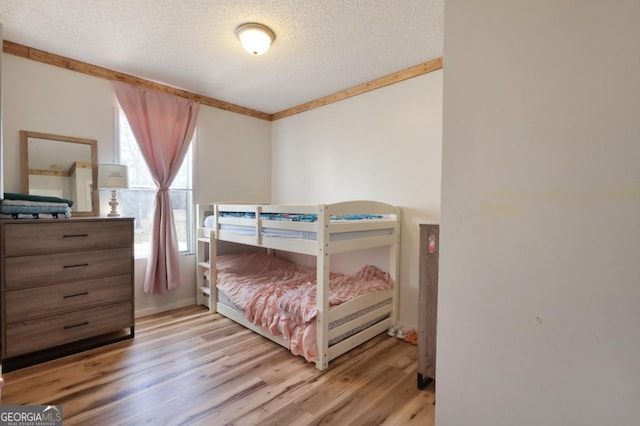 bedroom with a textured ceiling and wood finished floors