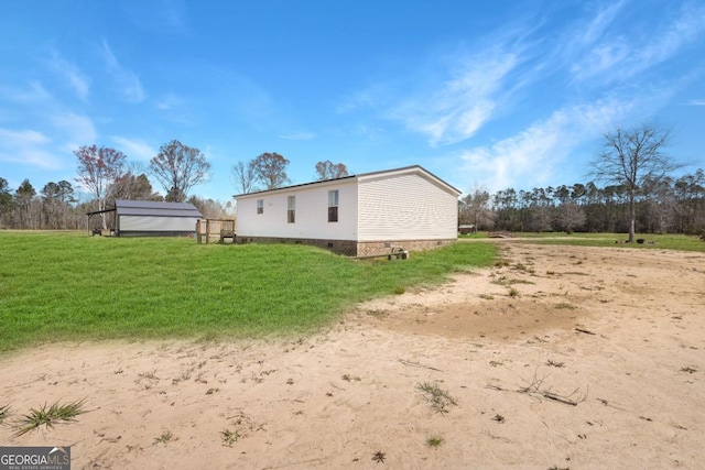 rear view of house featuring crawl space and a lawn