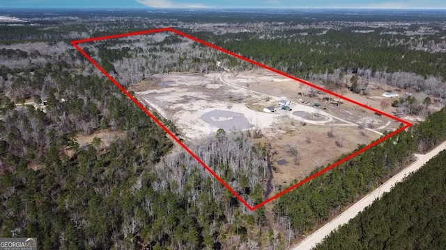 birds eye view of property featuring a forest view