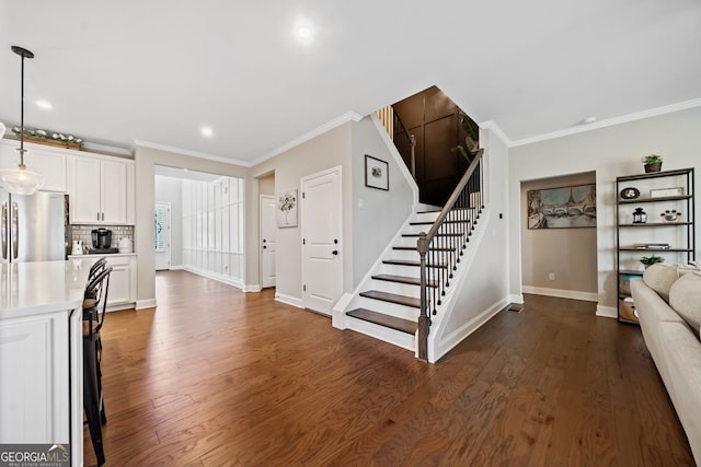 interior space with ornamental molding, dark wood finished floors, white cabinetry, freestanding refrigerator, and light countertops