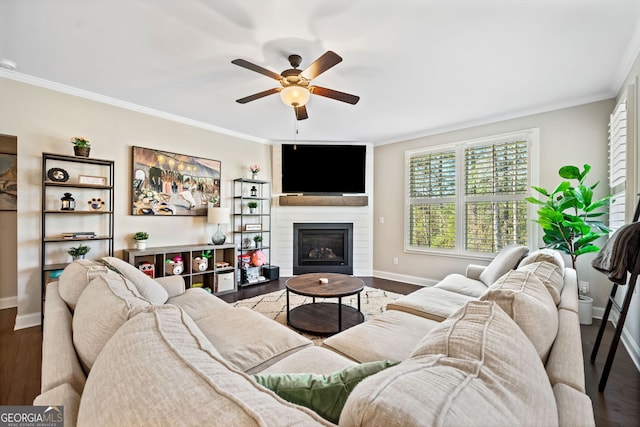 living room with dark wood finished floors, a large fireplace, and ornamental molding