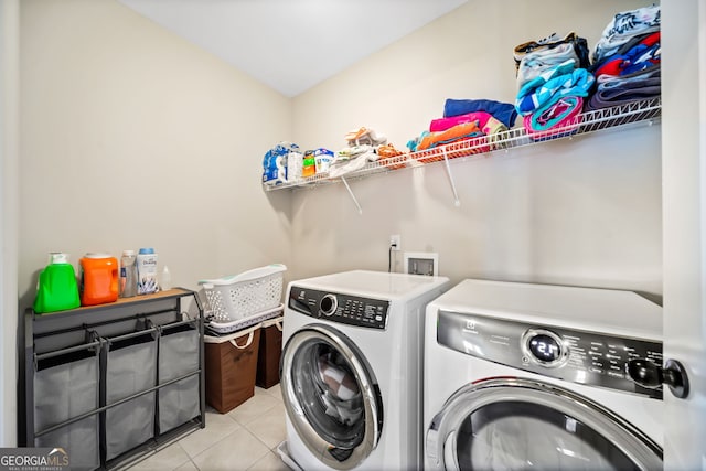 clothes washing area featuring washer and clothes dryer, laundry area, and light tile patterned floors