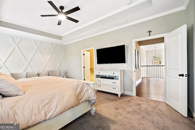 bedroom with visible vents, a raised ceiling, carpet floors, and ornamental molding